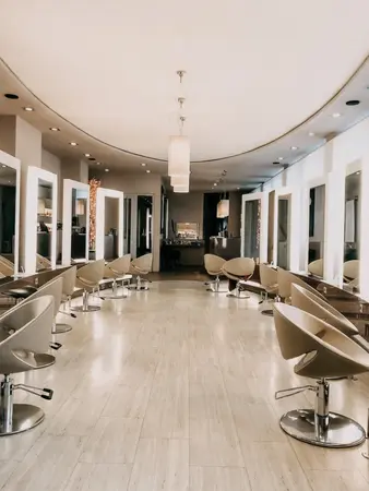 Moderner Friseursalon mit hellen Spiegeln, bequemen Stühlen und stilvollem Interieur.
